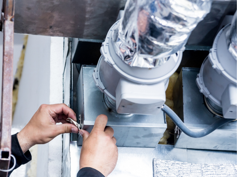 A technician fitting extract ducting as part of a ventilation improvement installation