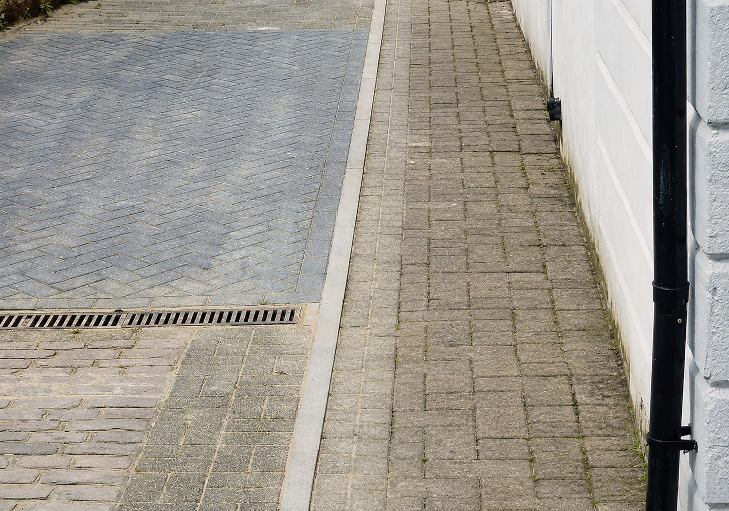 Raised paving against an exterior wall before damp bridging remedial work